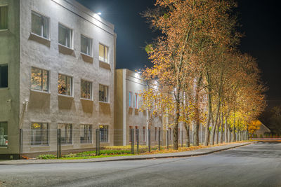 Street amidst trees and buildings at night