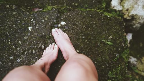 Cropped image of legs on rock