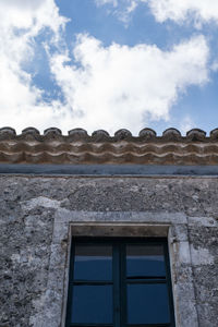 Low angle view of building against cloudy sky