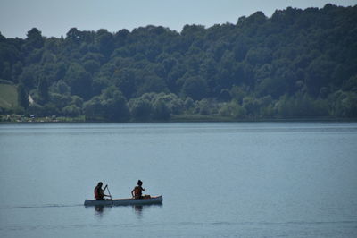 Rear view of people canoeing in lake