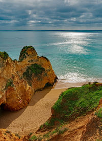 Rock formation on beach against sky