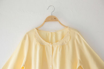 Yellow top hanging against wall