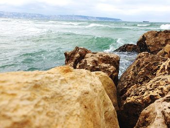 Rocks on beach against sky