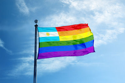 Low angle view of flags against blue sky
