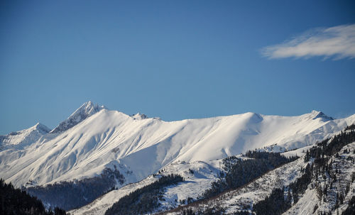 Scenic view of snowcapped mountains against clear blue sky