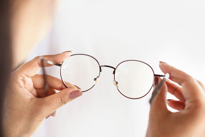 Woman hand hand holding eyeglasses closeup