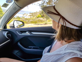 Side view of woman sitting in car