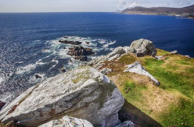 High angle view of rocks by sea against sky