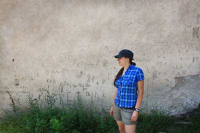 Full length of teenage girl standing against wall