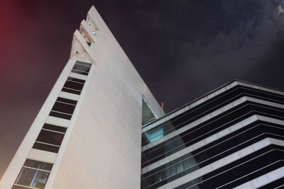 Low angle view of skyscraper against sky at night