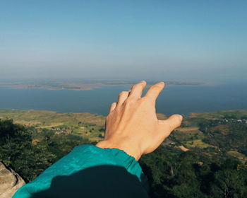 Midsection of person on mountain against sky