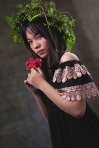 Portrait of woman holding red rose