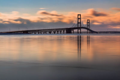 Bridge over sea against sky during sunset