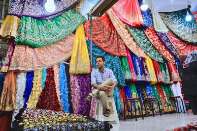 Low section of woman standing on multi colored market stall