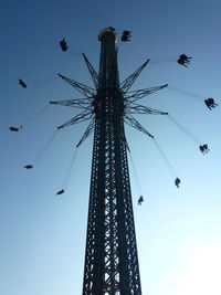 Low angle view of chain swing ride against clear blue sky