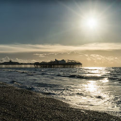 Scenic view of sea and pier against sky during sunrise