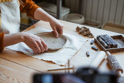 Hand modelling of openwork clay plate, pottery