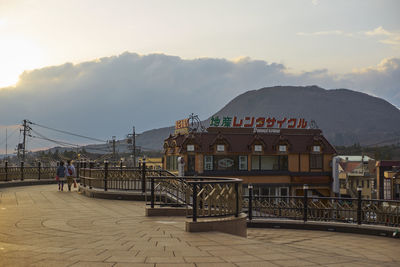 People on building against cloudy sky