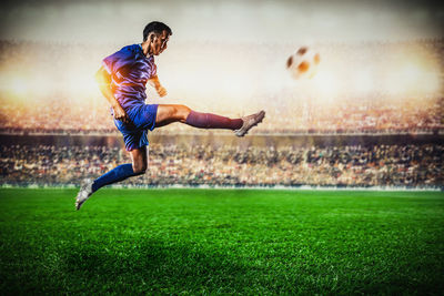 Woman playing soccer ball on grass