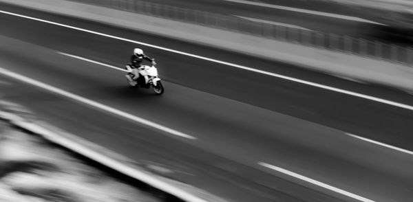 Blurred motion of man riding motorcycle