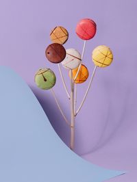 High angle view of colorful macaroons with sticks and paper on purple background