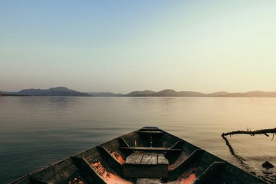 Cropped image of boat on lake against sky during sunset