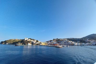 City by sea against clear blue sky