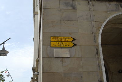 Low angle view of information sign on wall