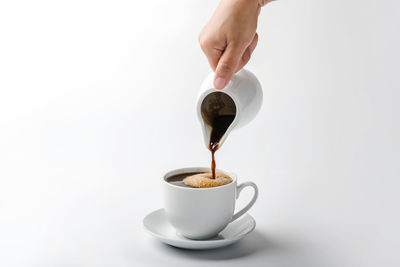 Hand holding coffee cup against white background