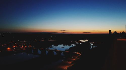 Silhouette city against clear sky during sunset