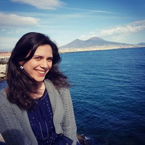 Portrait of smiling young woman in sea against sky