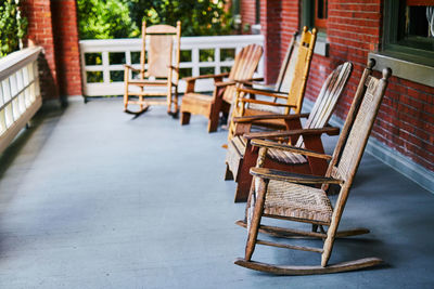 Empty chairs and tables against building