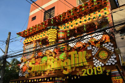 Low angle view of lanterns hanging by building against sky