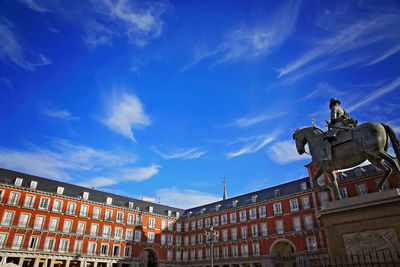 Low angle view of statue against building against sky