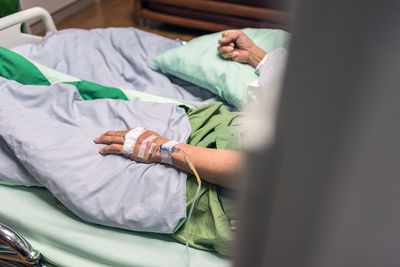 Person with iv drop on bed at hospital 