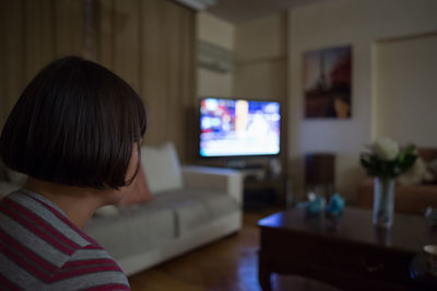 Close-up of girl watching tv at home