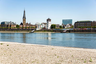 River by buildings against sky in city