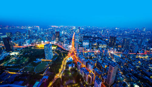 High angle view of city lit up at night