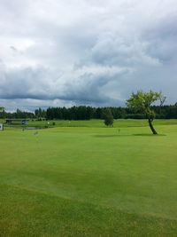 Scenic view of golf course against sky