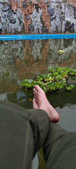 Midsection of man holding umbrella against wall