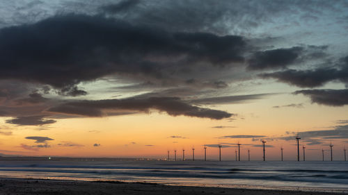 Scenic view of sea against dramatic sky during sunset