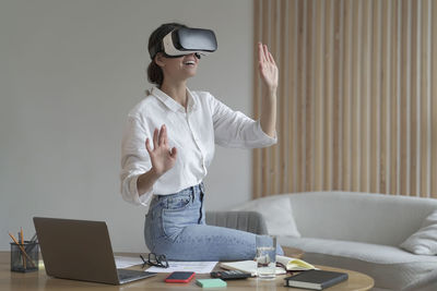 Portrait of young woman using digital tablet while sitting on table