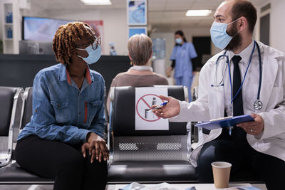 Rear view of doctor examining patient in hospital