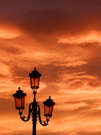 Low angle view of street light against orange sky