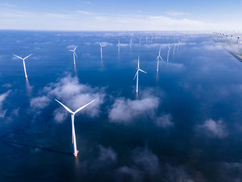 Low angle view of wind turbines against sky
