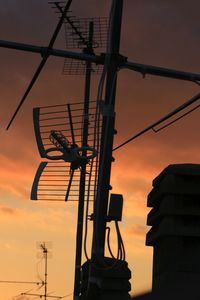 Low angle view of silhouette crane against sky during sunset