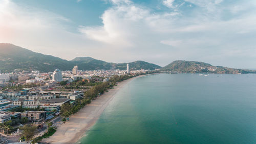 High angle view of city by sea against sky