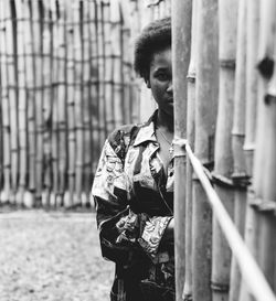 Young woman standing in front of a bamboo fence