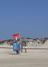 Lifeguard hut on desert against clear blue sky