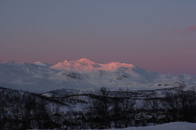 Scenic view of snowcapped mountains against sky during sunset